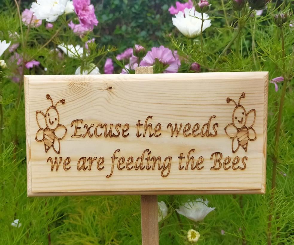 Excuse the weeds we are feeding the bees outdoor garden sign - Front view 